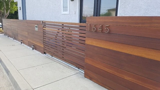 Horizontal hardwood front fence with a sliding gate and house numbers