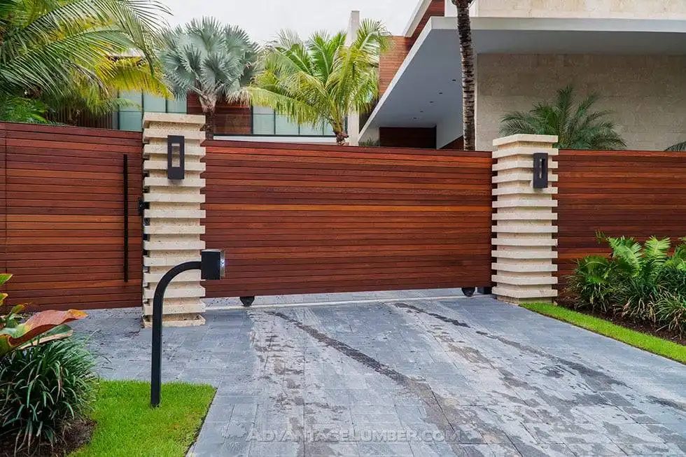 Modern horizontal timber fence and sliding driveway gate with stone pillars