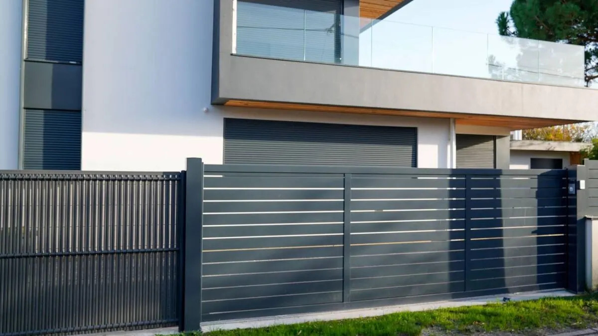 Modern dark grey horizontal slat aluminium fence and gate in front of a contemporary New Zealand home