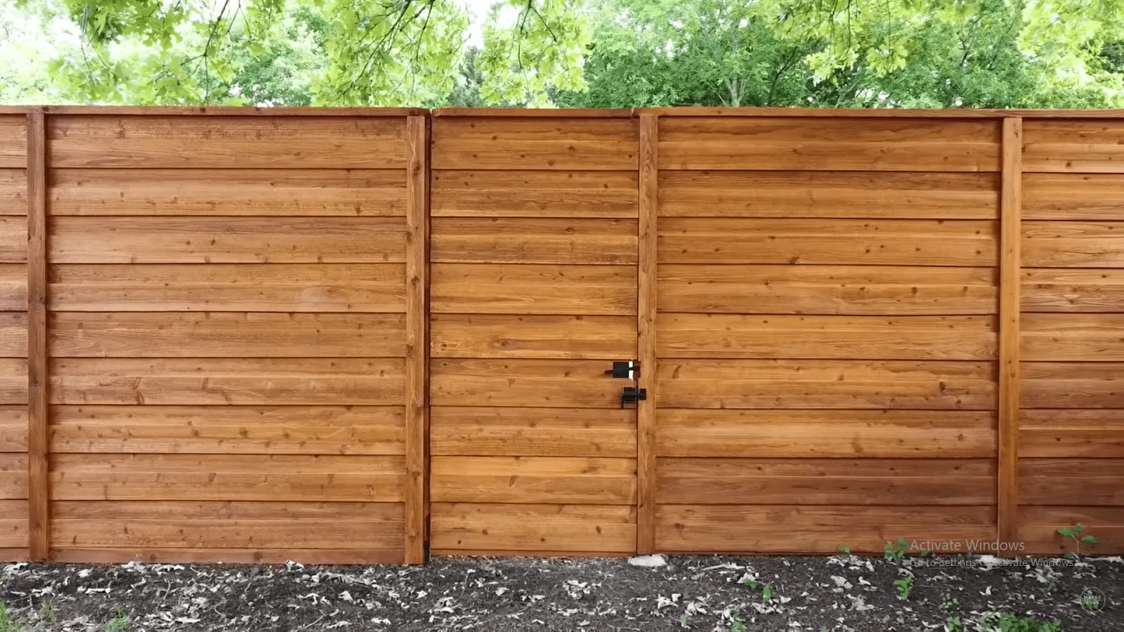 Stained horizontal timber fence with a matching gate