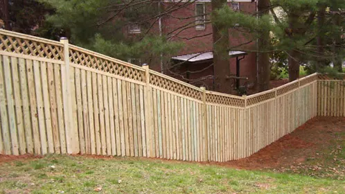A wooden fence with a lattice top installed on a slope