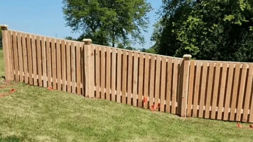 A wooden picket fence installed on a grassy slope