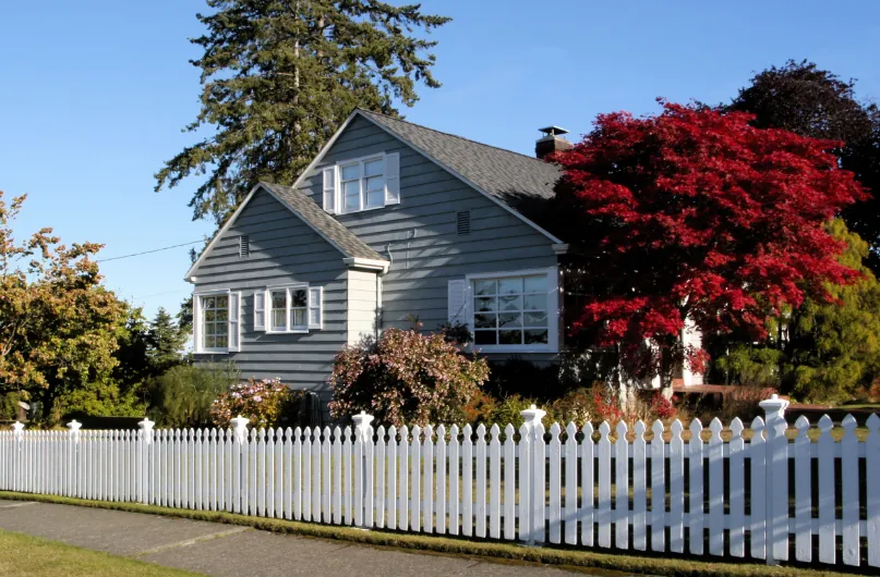 A house with a white picket fence in front of it